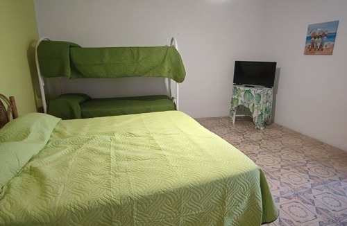 Stromboli Villa | Green room with 4 beds, bathroom and patio with equipped kitchen